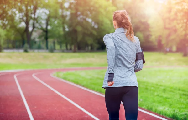 Спортивная женщина бегает на треке назад зрения, здоровый образ жизни — стоковое фото