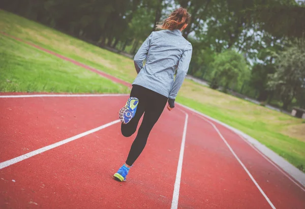 Athletic woman running on track back view, healthy lifestyle — Stock Photo, Image