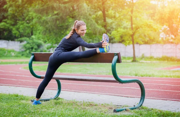 Athletische Frau dehnt sich vor dem Lauftraining — Stockfoto