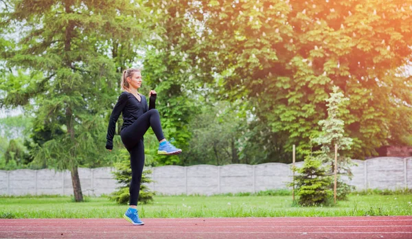 Mujer atlética estirándose en pista de atletismo antes del entrenamiento, estilo de vida saludable — Foto de Stock