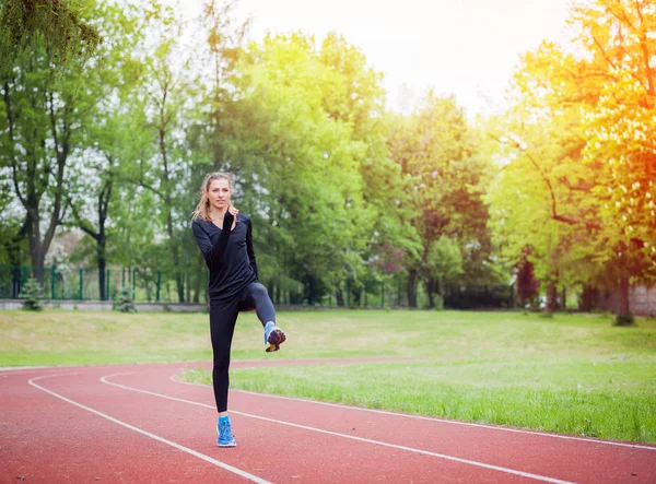 Mujer atlética estirándose en pista de atletismo antes del entrenamiento, estilo de vida saludable — Foto de Stock