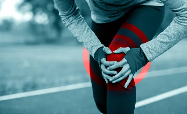 Mujer atlética en pista de atletismo tocando pierna herida con rodilla inju — Foto de Stock