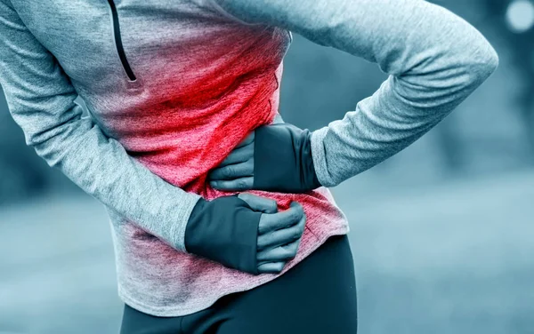 Frau auf Laufstrecke hat beim Training Seitenkrämpfe — Stockfoto