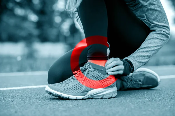 Athletic woman on running track touching hurt leg with ankle inj — Stock Image Athletic woman on running track touching hurt leg with ankle inj Stock Photo