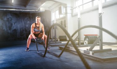 Fitness woman working out with battle rope, crossfit training clipart