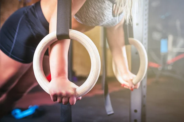 Woman working out with gymnastic rings at crossfit gym — Stock Photo, Image