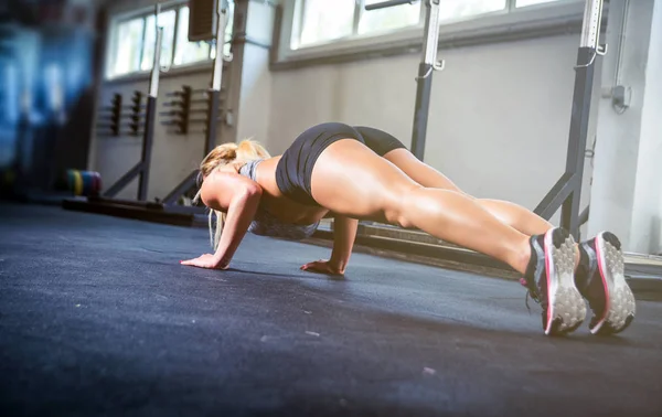 Fitness vrouw doet push ups training op de sportschool — Stockfoto
