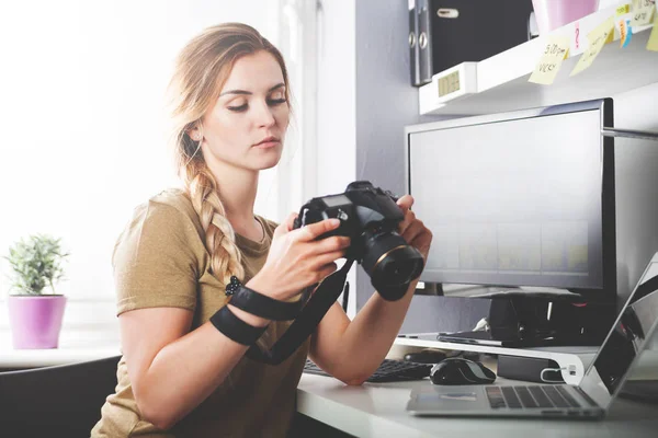 ホーム オフィス編集でカメラを持つフリーランスのカメラマン女性 — ストック写真