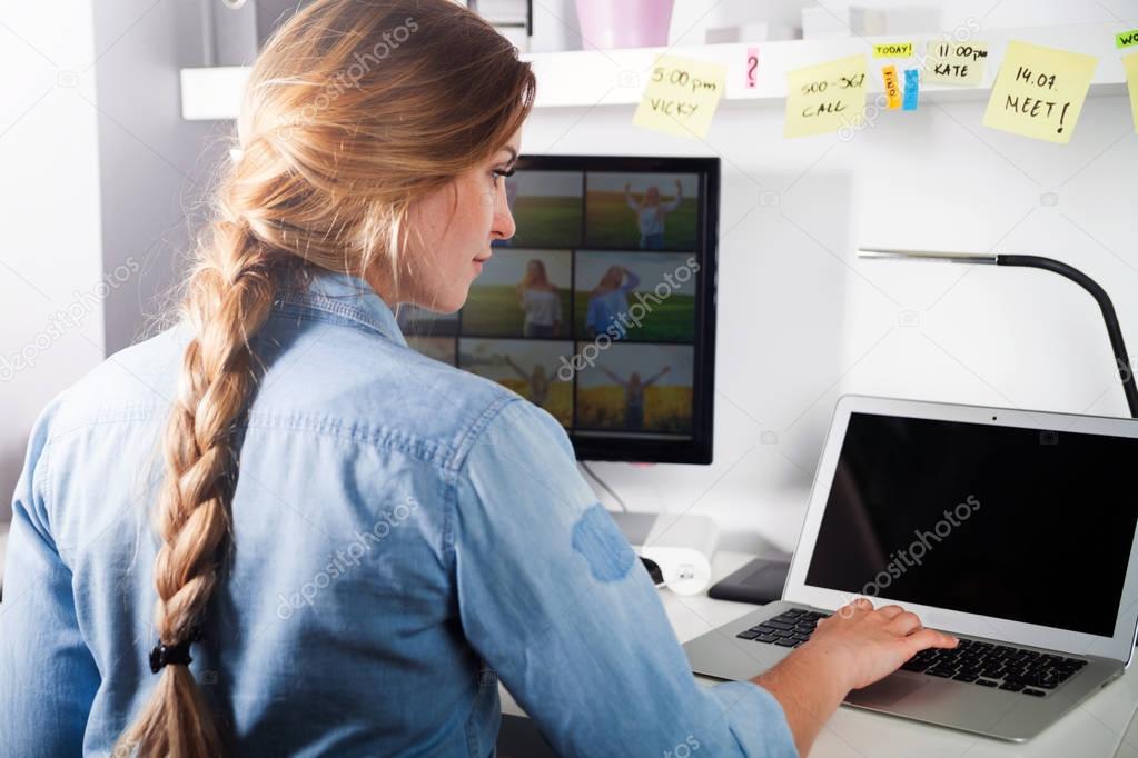 Young woman working on computer, home office desk