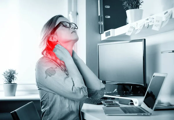 Woman in home office suffering from neck pain sitting at desk — Stock Photo, Image