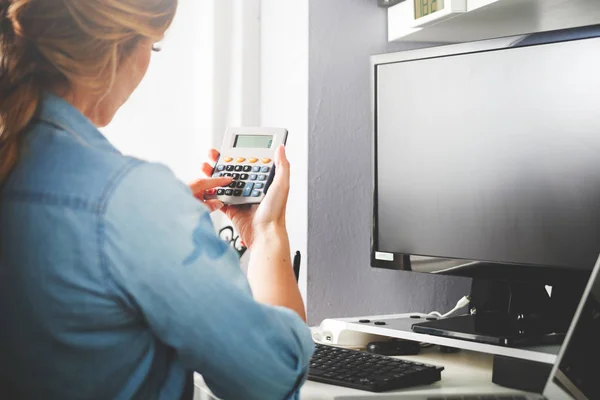 Vrouw op kantoor aan huis met behulp van de rekenmachine, berekening van de begroting — Stockfoto