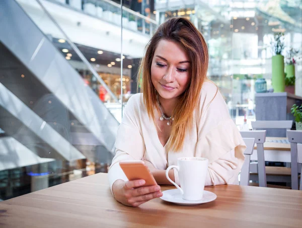 Chica usando el teléfono móvil en la cafetería en el centro comercial —  Fotos de Stock