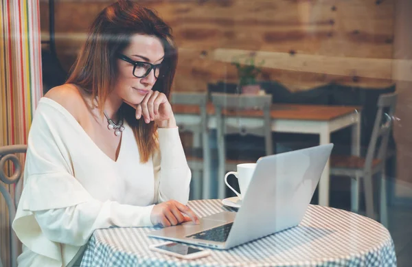 Mujer de negocios que trabaja con portátil y teléfono móvil en la cafetería, concepto independiente — Foto de Stock