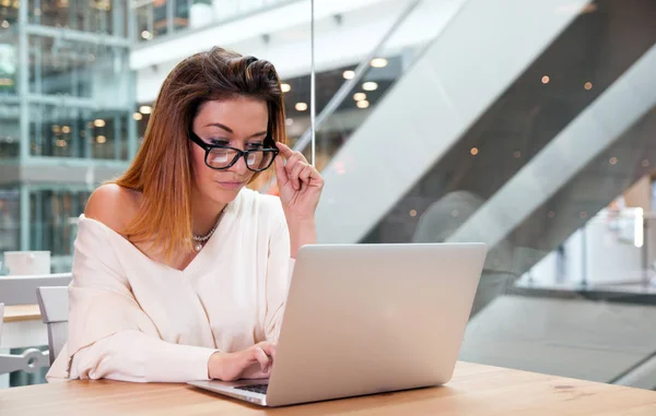 Geschäftsfrau mit Laptop arbeitet im Großraumbüro in modernem Interieur, freiberufliches Konzept — Stockfoto