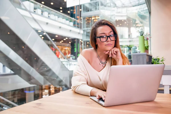 Mujer de negocios con portátil que trabaja en la oficina de espacio abierto en el interior moderno — Foto de Stock