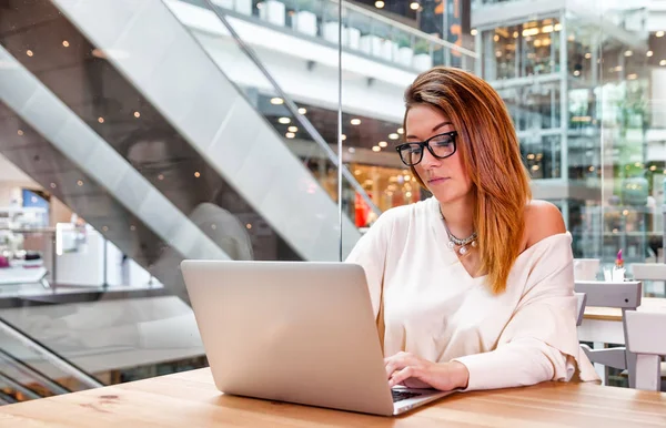 Mujer de negocios con portátil que trabaja en la oficina de espacio abierto en el interior moderno — Foto de Stock