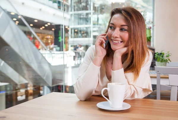 Dívka mluví na mobilním telefonu v kavárně v nákupní centrum — Stock fotografie