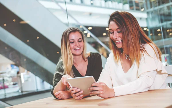 Dijital kullanarak iki kadın kız café'de alışveriş merkezi izlerken medya içeriklerinde tablet