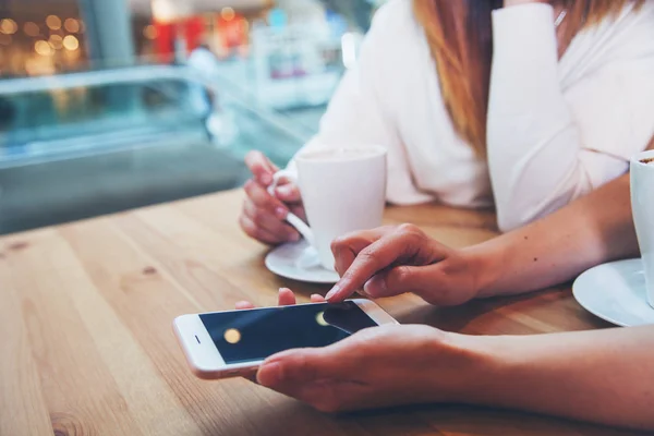 Deux amis filles dans le café en utilisant le téléphone mobile et les textos, gros plan — Photo