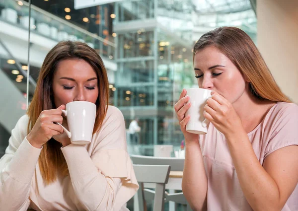 Spotkanie przyjaciół kobiety picie w kawiarni w centrum handlowym — Zdjęcie stockowe