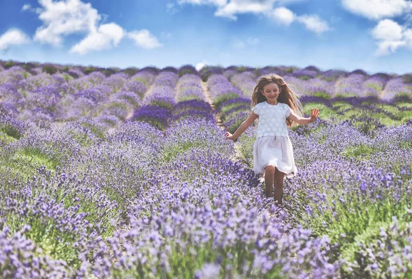 Krásné dítě dívka utíká v levandulové pole letní svobodu koncept — Stock fotografie