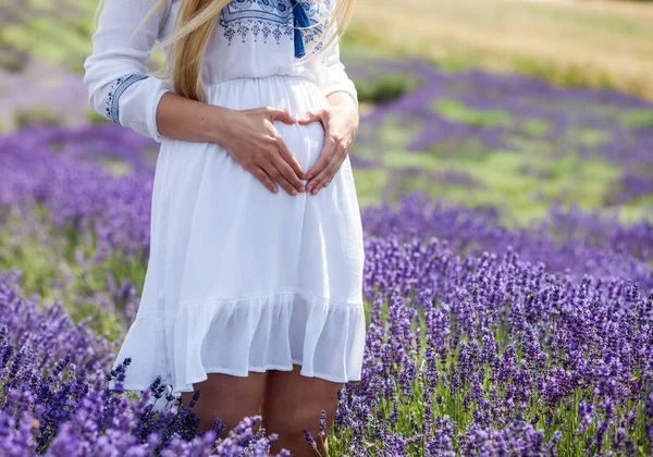 Pregnant woman in white dress on lavender field at sunny day — Stock Photo, Image