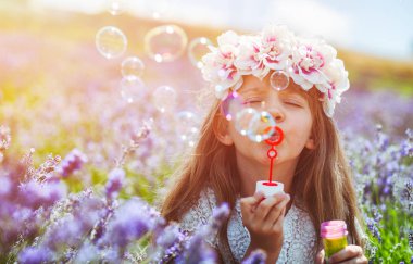 Sabun köpüğü üfleme ve lavanta alanında having fun kız çocuk