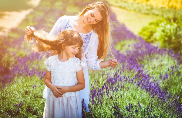 Семейный портрет в лавандовом поле, мать и дочь веселятся — стоковое фото