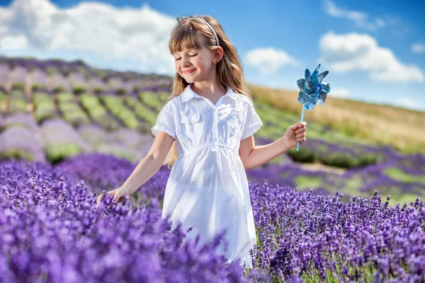 Enfant fille marche dans le champ de lavande, concept d'enfance heureuse — Photo
