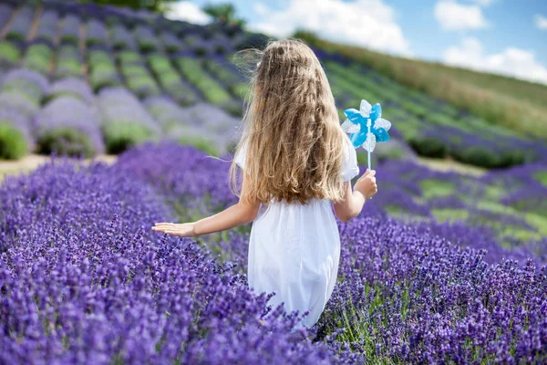 Menina criança caminhando no campo de lavanda, conceito de infância feliz — Fotografia de Stock