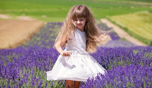 Девочка танцует на лавандовом поле в летний день, концепция свободы — стоковое фото