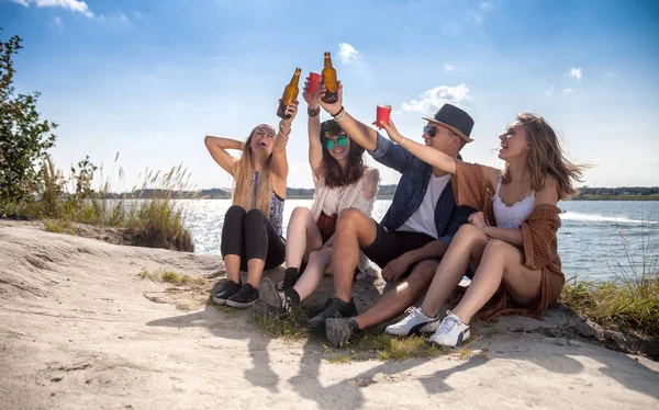 Vrienden met plezier en drinken op het strand, positieve stemming — Stockfoto