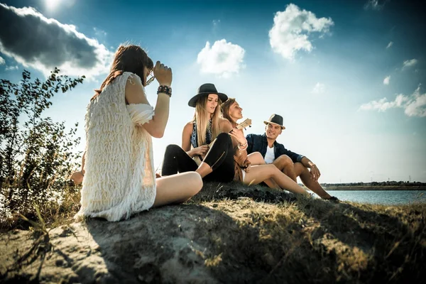 Friends partying at the beach playing ukulele, positive mood