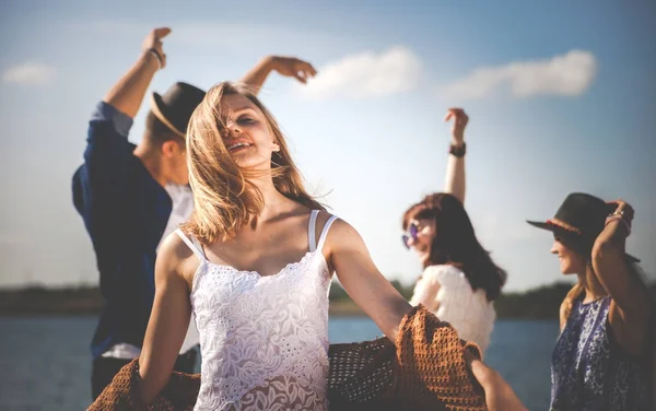 Groupe d'amis dansant et célébrant sur la plage, fête en plein air — Photo