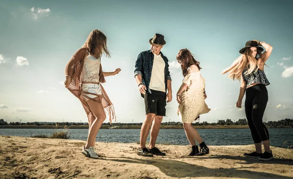 Group of friends partying and dancing at the beach