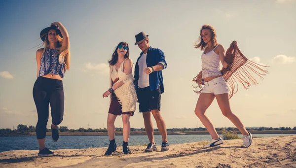 Gruppo di amici che festeggiano e ballano in spiaggia — Foto Stock