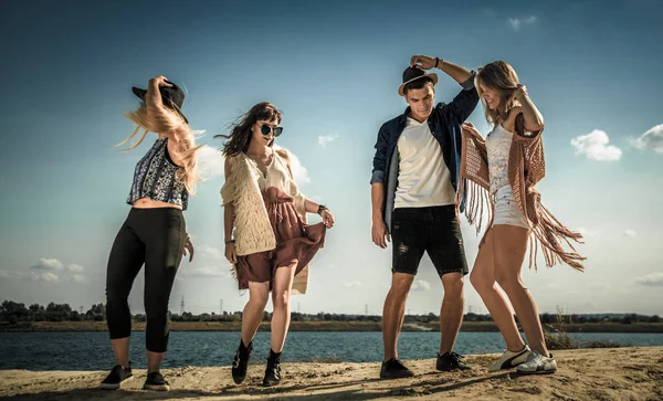 Группа друзей тусуется и танцует на пляже — стоковое фото