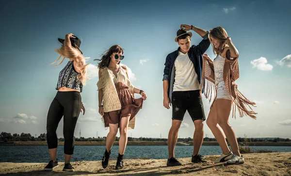 Group of friends partying and dancing at the beach