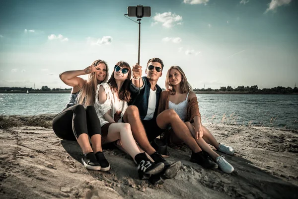 Groupe d'amis prenant autoportrait avec selfie stick, s'amuser à la plage — Photo