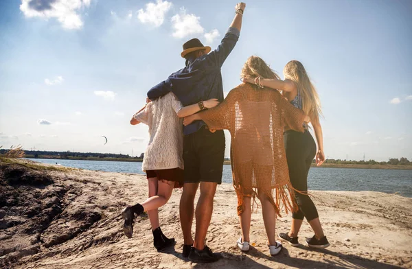 Groep gelukkige vrienden wandelen op strand, positieve stemming — Stockfoto