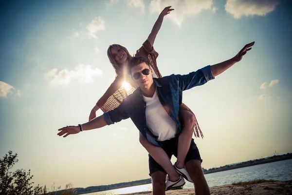 Pareja feliz divirtiéndose al aire libre al atardecer, amor y amistad — Foto de Stock