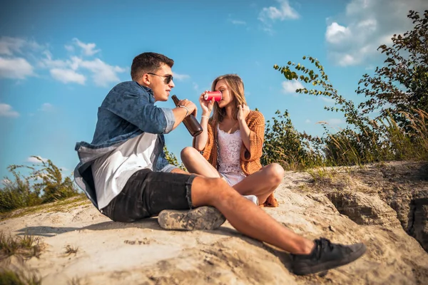 Glückliches Paar sitzt am Strand und trinkt, Liebe und Freundschaft — Stockfoto