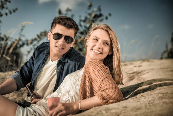 Gelukkige paar zittend op het strand, de liefde en de vriendschap — Stockfoto