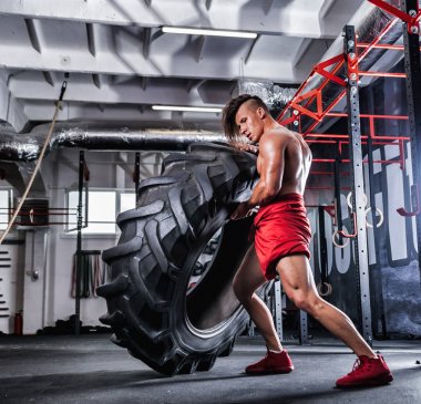 Lastik spor salonu çapraz saygısız kaslı atletik vücut geliştirmeci