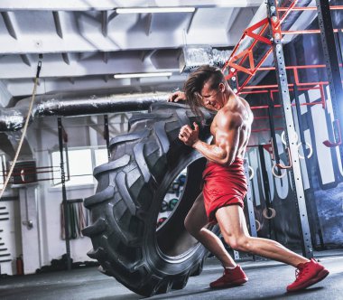 Lastik spor salonu çapraz saygısız kaslı atletik vücut geliştirmeci