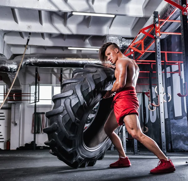 Lastik spor salonu çapraz saygısız kaslı atletik vücut geliştirmeci