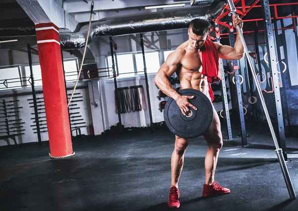 Muscular fit bodybuilder like Spartan warrior working out in gym