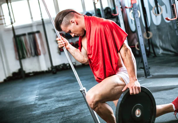 Muscular fit bodybuilder like Spartan warrior working out in gym