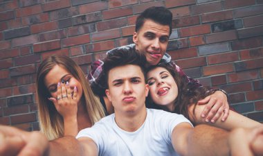 İn arkadaş grubu ile tuğla duvar üzerine Selfie