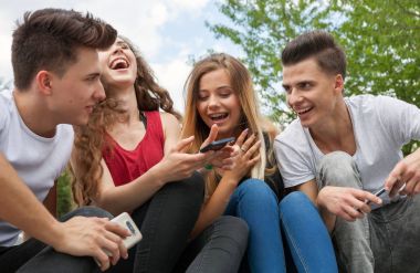 Arkadaş birlikte telefonlarını kullanarak oturma grubu